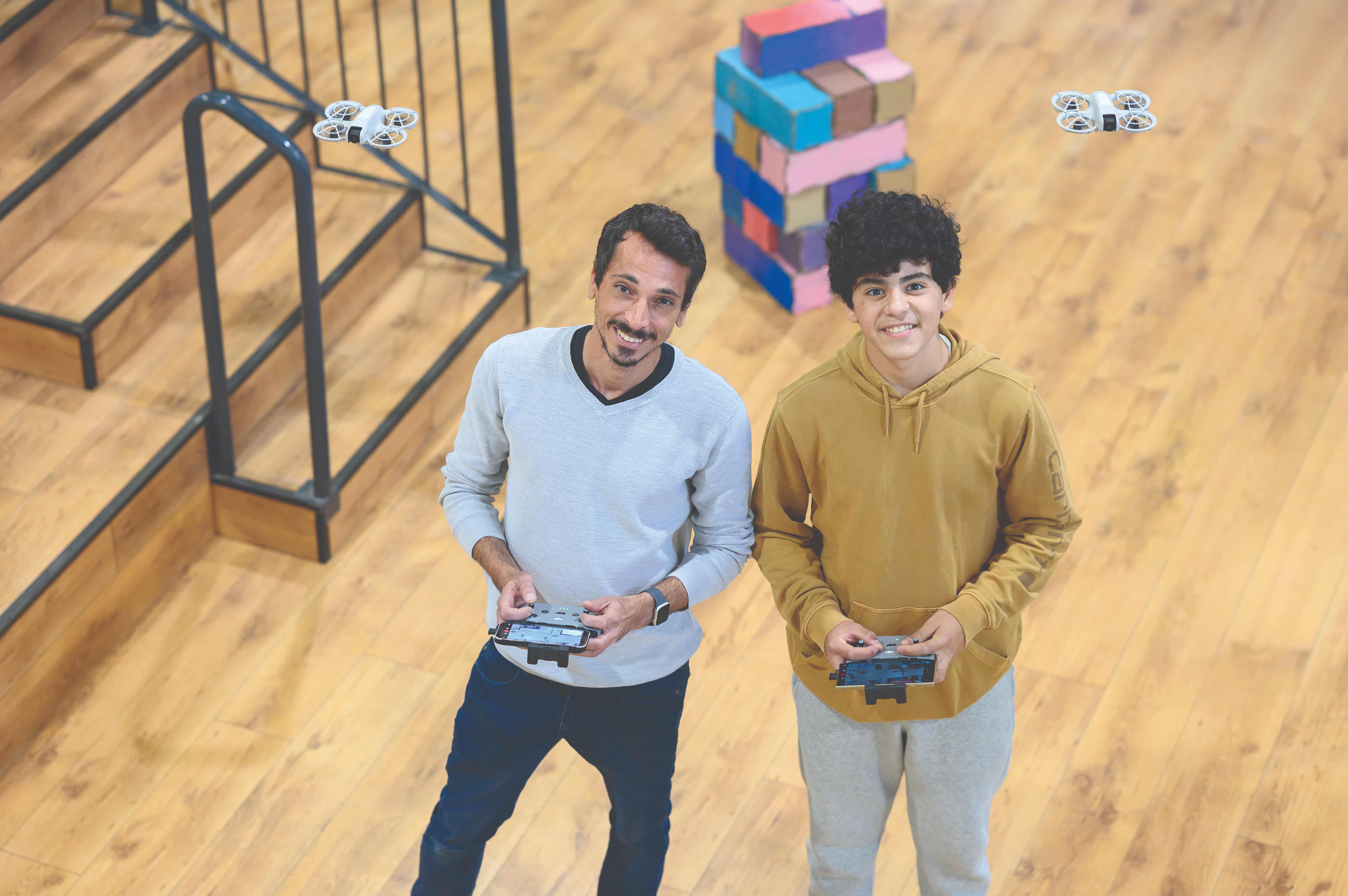 Shani Medina, GrooveTech director (left), and Ben (right) operate drones in GrooveTech’s auditorium (Photo by Ron Rahamim)