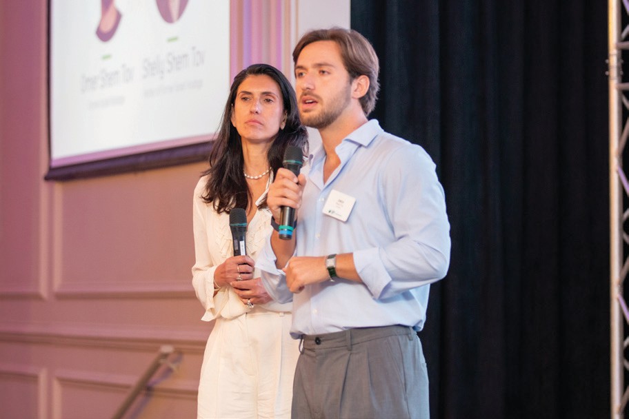 Former Israeli hostages are honored onstage at a Jewish National Fund-USA event, with one addressing the audience by microphone.