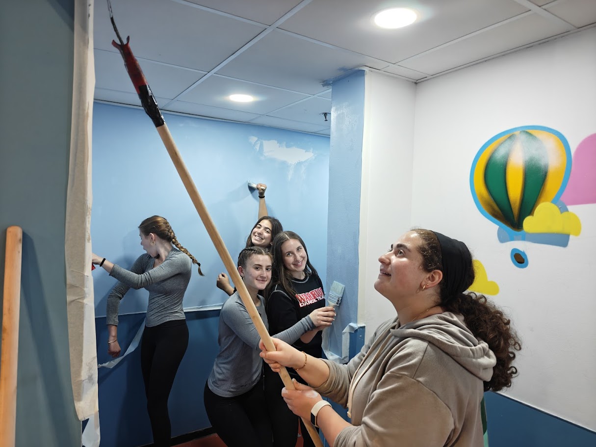The volunteering image supports the broader theme of hands-on growth, community, Zionist identity, and students becoming leaders through real experiences in Israel.