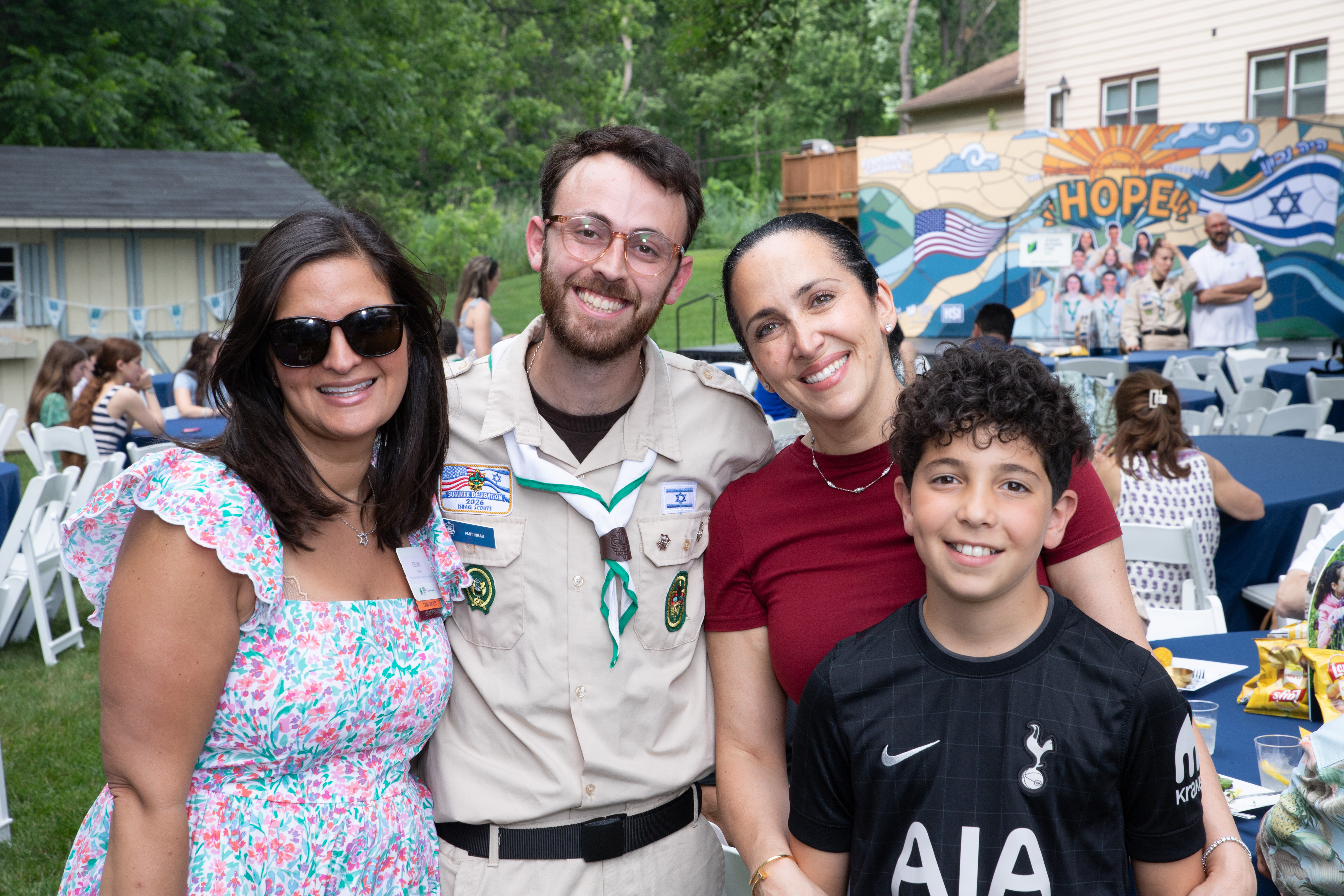 Jewish National Fund-USA supporters pose with a Tzofim Friendship Caravan member at an outdoor Livingston event.