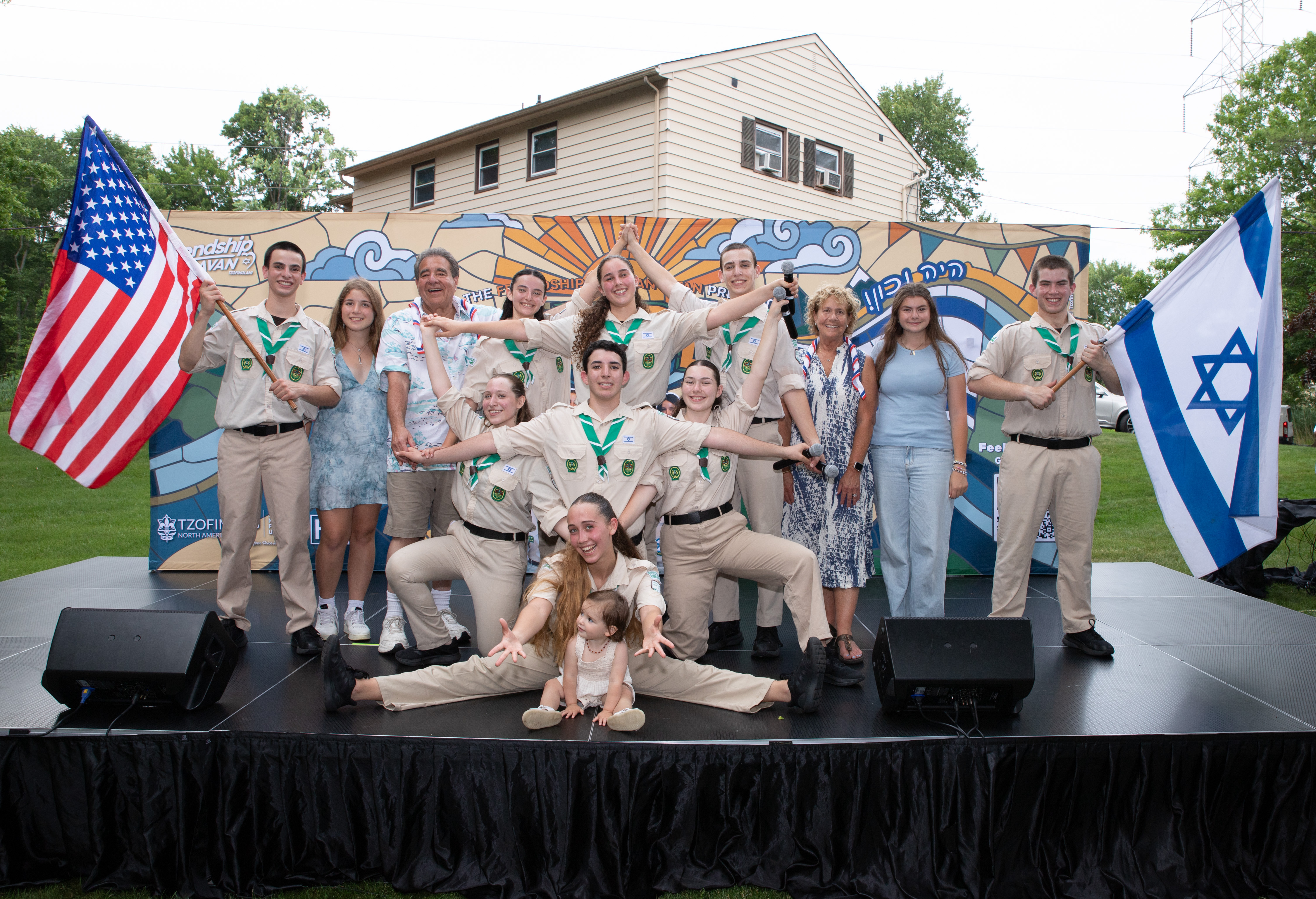 Israeli Scouts and Jewish National Fund-USA supporters pose on stage with American and Israeli flags at a Livingston gathering.