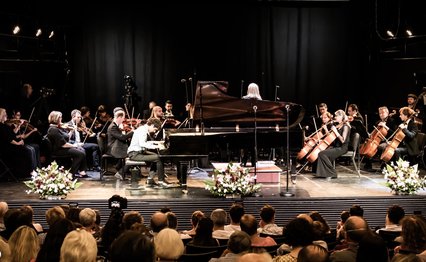 Pianist and orchestra performing onstage at the Arad Piano Festival.